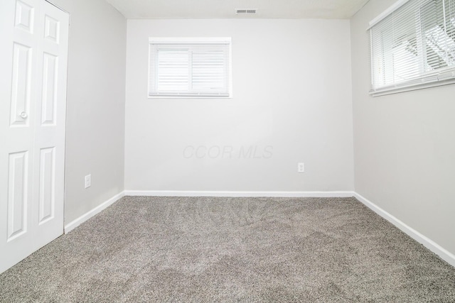 unfurnished room featuring baseboards, visible vents, and carpet flooring