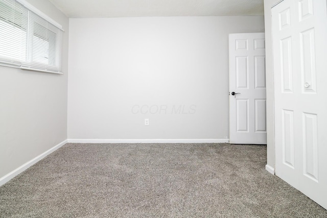 empty room with carpet flooring and baseboards