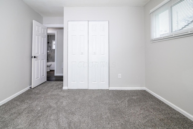 unfurnished bedroom featuring a closet, carpet flooring, and baseboards