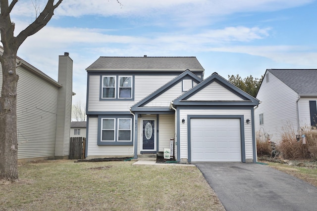 traditional-style house featuring aphalt driveway, a front lawn, an attached garage, and fence