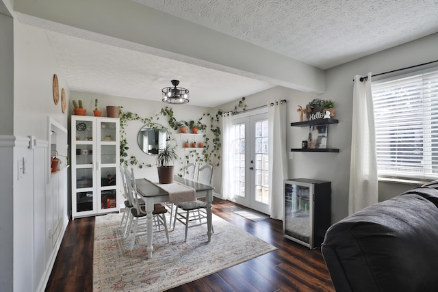 dining room featuring french doors, beverage cooler, a textured ceiling, and wood finished floors