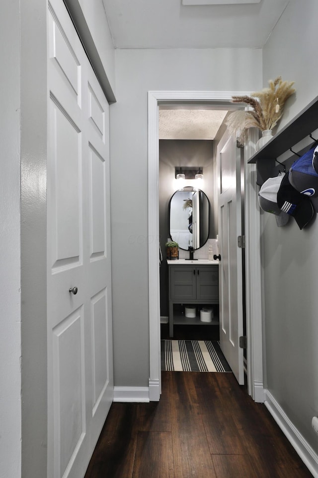 hall with dark wood-style floors and baseboards