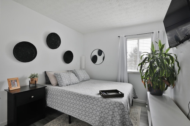 bedroom with a textured ceiling and wood finished floors