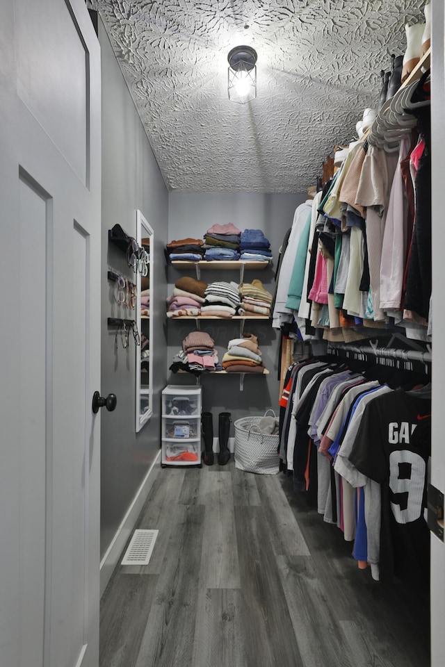 spacious closet featuring wood finished floors and visible vents