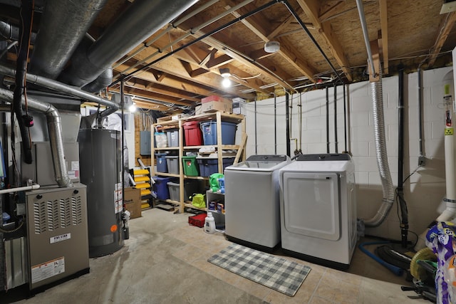 unfinished below grade area featuring heating unit, electric panel, separate washer and dryer, and gas water heater