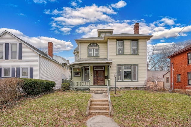 view of front of property featuring a porch, a chimney, and a front lawn