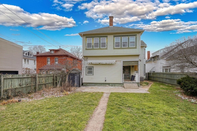 rear view of house featuring a fenced backyard, a lawn, a chimney, and central air condition unit