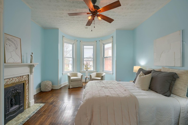 bedroom featuring a textured ceiling, a fireplace with flush hearth, dark wood finished floors, and baseboards