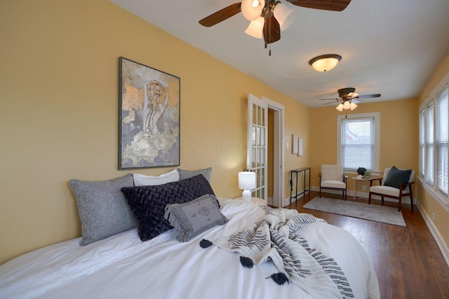 bedroom with wood finished floors, a ceiling fan, and baseboards