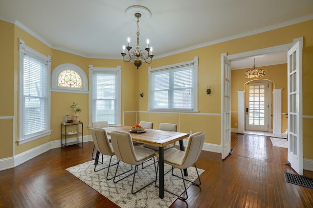 dining room featuring baseboards, a wealth of natural light, hardwood / wood-style flooring, and a notable chandelier