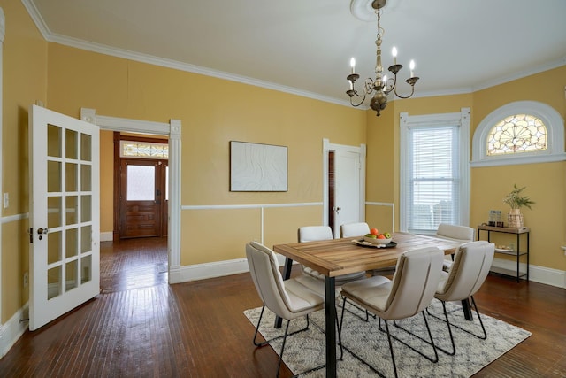 dining space featuring baseboards, ornamental molding, hardwood / wood-style flooring, and an inviting chandelier