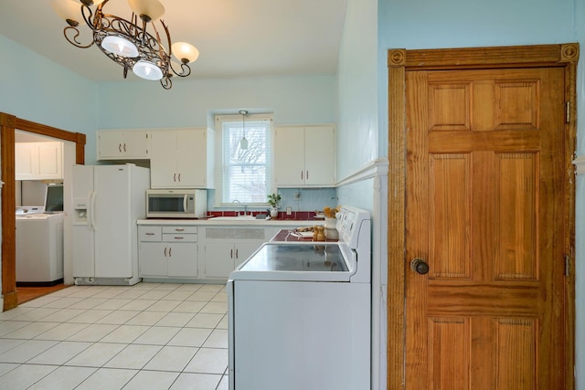 kitchen with light tile patterned flooring, white appliances, a sink, white cabinets, and washer / clothes dryer