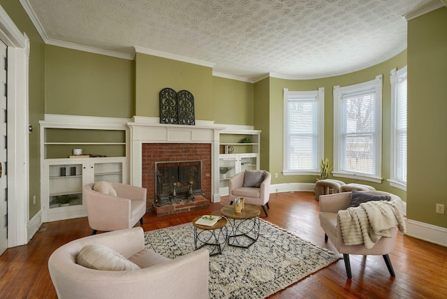 living room featuring a textured ceiling, crown molding, a fireplace, and wood finished floors