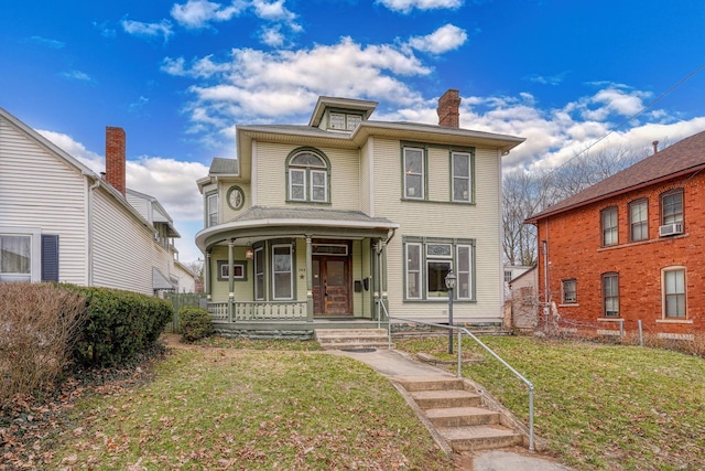 view of front of home with a front yard, covered porch, cooling unit, and a chimney