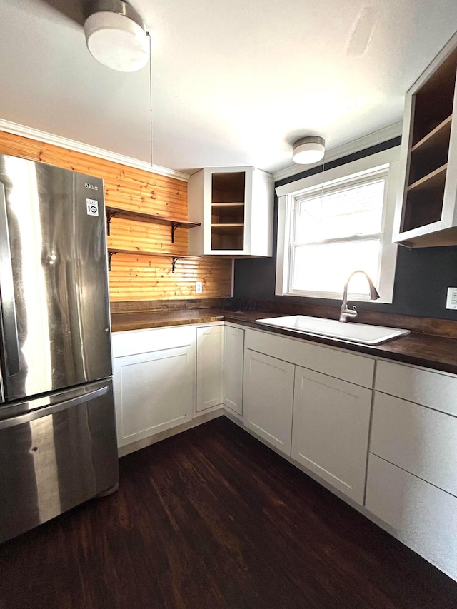 kitchen featuring freestanding refrigerator, dark wood finished floors, a sink, and open shelves