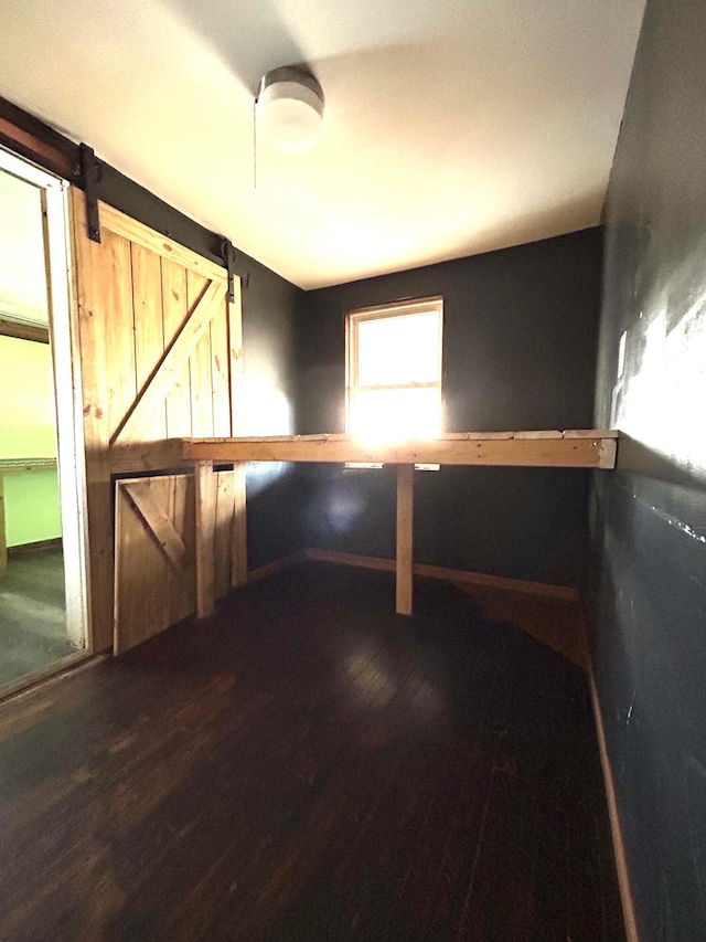 spare room featuring a barn door and wood finished floors