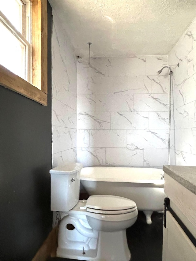 full bathroom with a textured ceiling, vanity, toilet, and tile walls