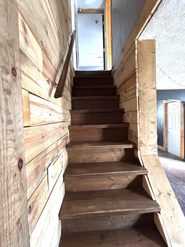 stairs featuring wooden walls