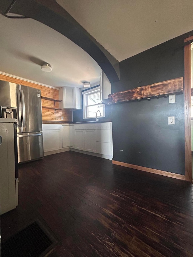 kitchen with decorative backsplash, baseboards, white cabinetry, stainless steel refrigerator with ice dispenser, and dark wood-style floors
