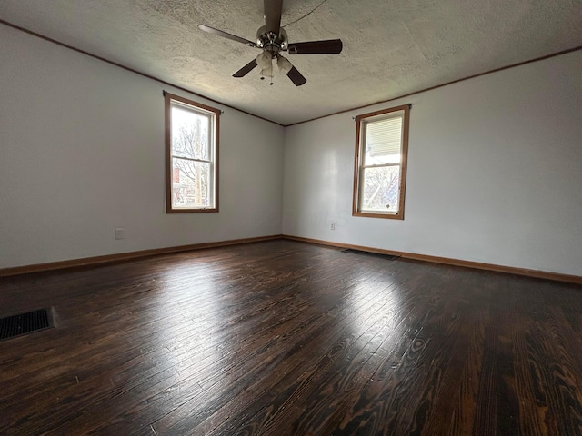 unfurnished room with a healthy amount of sunlight, wood-type flooring, visible vents, and a ceiling fan