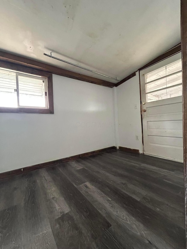 empty room with baseboards and dark wood-style flooring