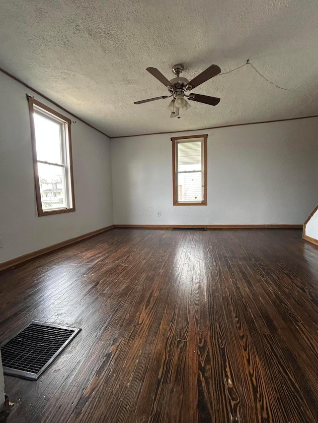 spare room featuring baseboards, visible vents, a ceiling fan, and wood-type flooring