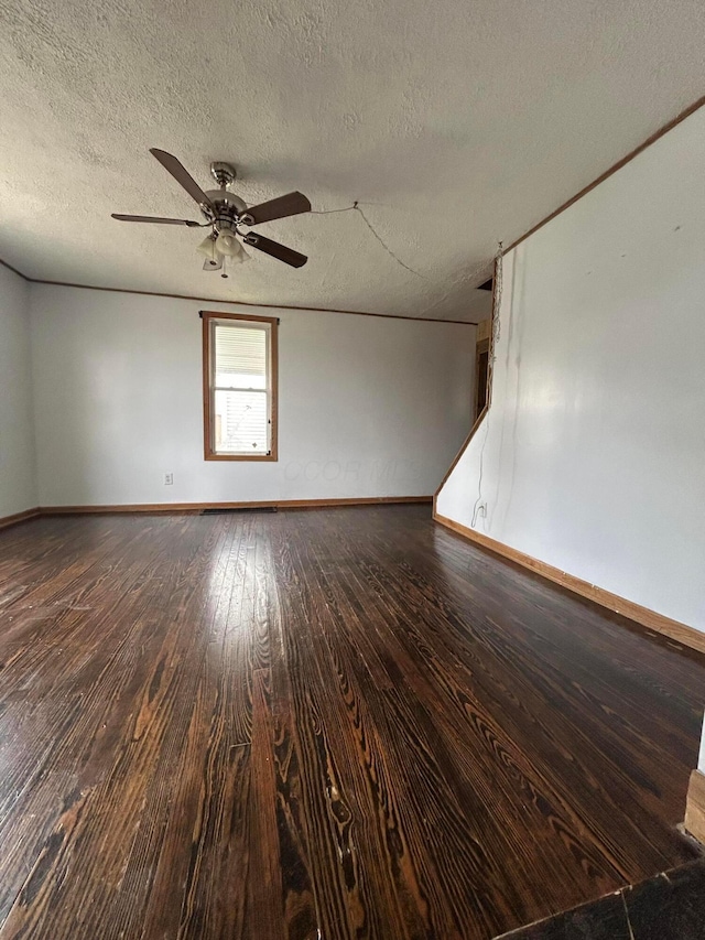 spare room with a ceiling fan, a textured ceiling, baseboards, and wood finished floors