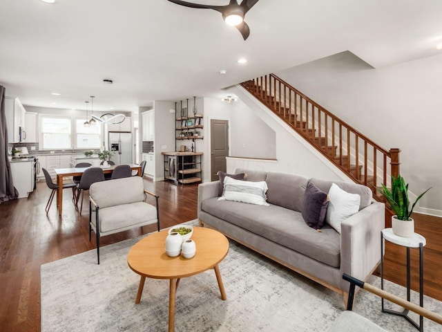 living area with recessed lighting, wood finished floors, and stairs