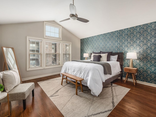 bedroom with baseboards, an accent wall, wood finished floors, and wallpapered walls