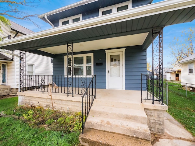 view of front of property featuring covered porch and fence