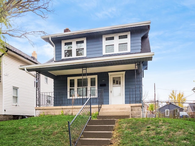 american foursquare style home featuring covered porch and a chimney