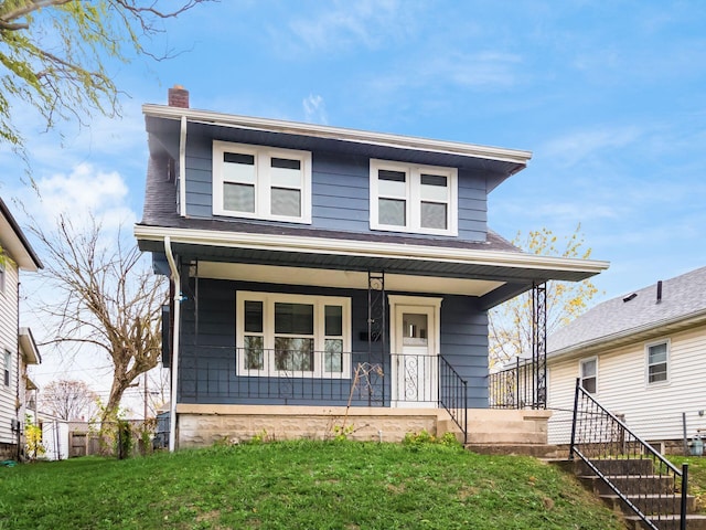 view of front of house with a porch, a shingled roof, a chimney, and a front lawn