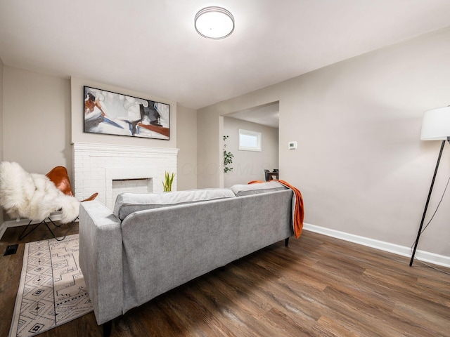 living room with a fireplace, wood finished floors, and baseboards