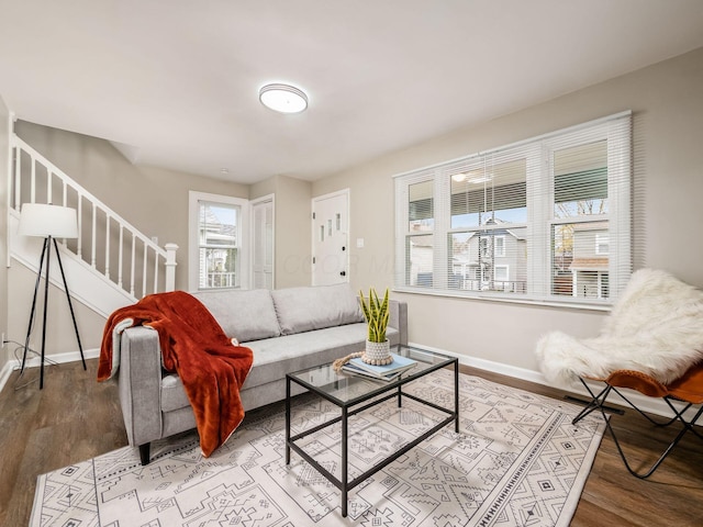 living area featuring stairs, baseboards, and wood finished floors