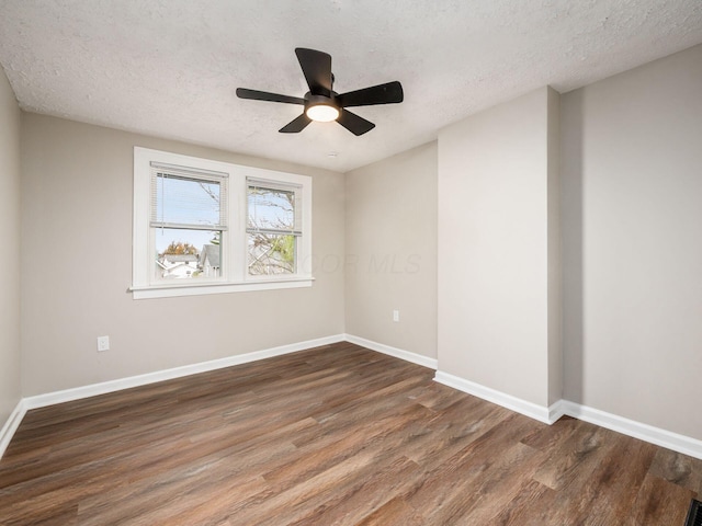 unfurnished room featuring a textured ceiling, wood finished floors, a ceiling fan, and baseboards