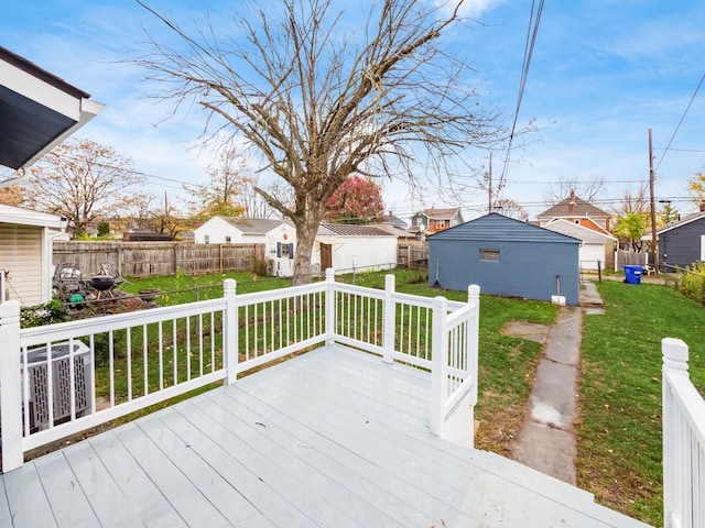 wooden terrace with a lawn, an outdoor structure, fence, and a residential view