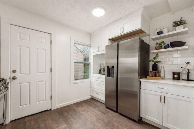 kitchen with dark wood-style flooring, stainless steel appliances, light countertops, backsplash, and white cabinetry