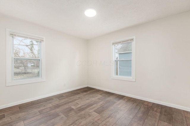 spare room with wood finished floors and baseboards