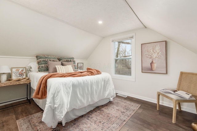 bedroom featuring dark wood-style floors, vaulted ceiling, visible vents, and baseboards