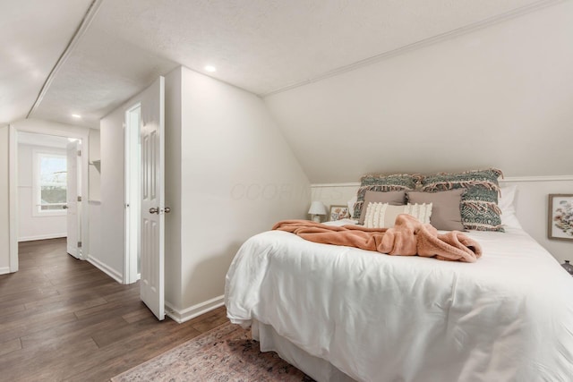 bedroom with lofted ceiling, baseboards, wood finished floors, and recessed lighting