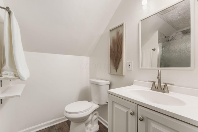 bathroom featuring toilet, wood finished floors, visible vents, vanity, and vaulted ceiling