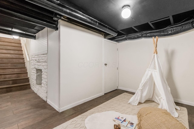 finished basement featuring stairway, baseboards, and wood finished floors