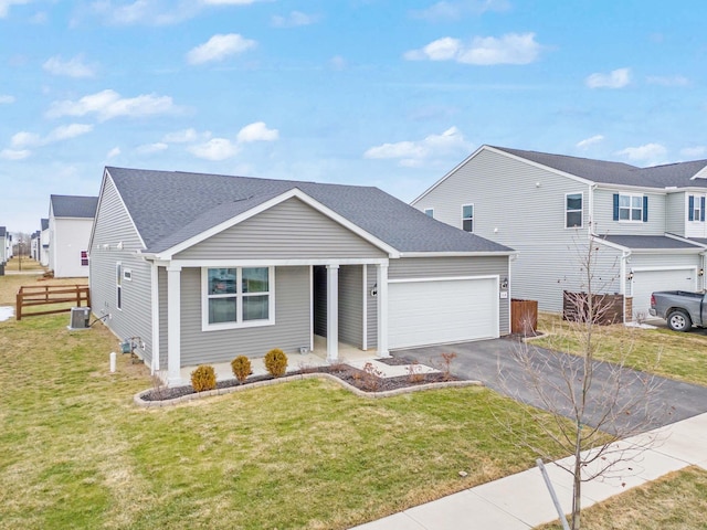 view of front of property featuring central AC unit, a garage, fence, driveway, and a front lawn