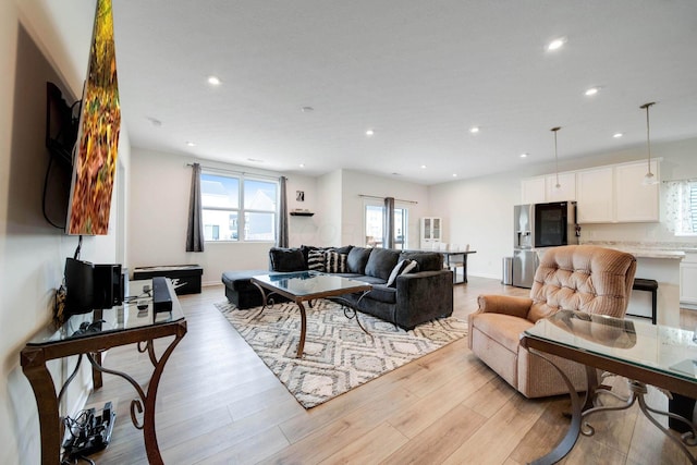 living area featuring baseboards, light wood-style flooring, and recessed lighting