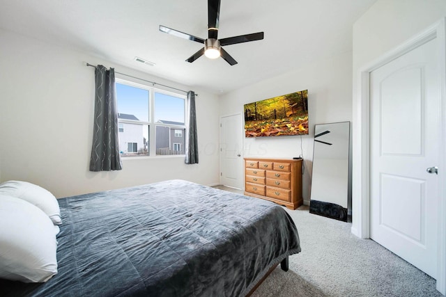 carpeted bedroom featuring ceiling fan, visible vents, and baseboards