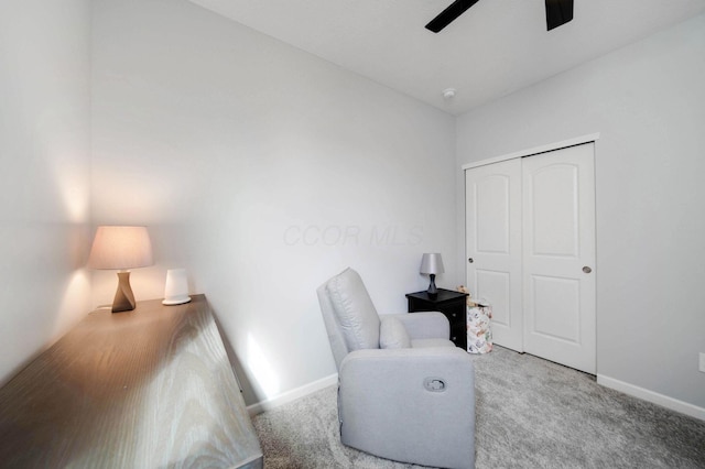 living area with carpet, baseboards, and ceiling fan