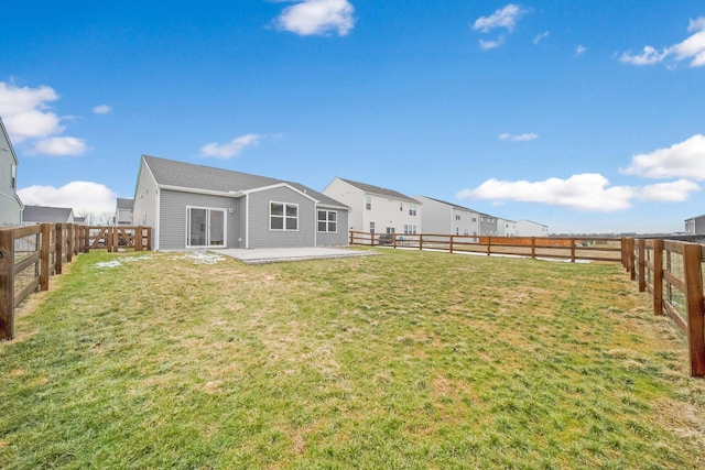 rear view of property featuring a yard, a patio, and a fenced backyard