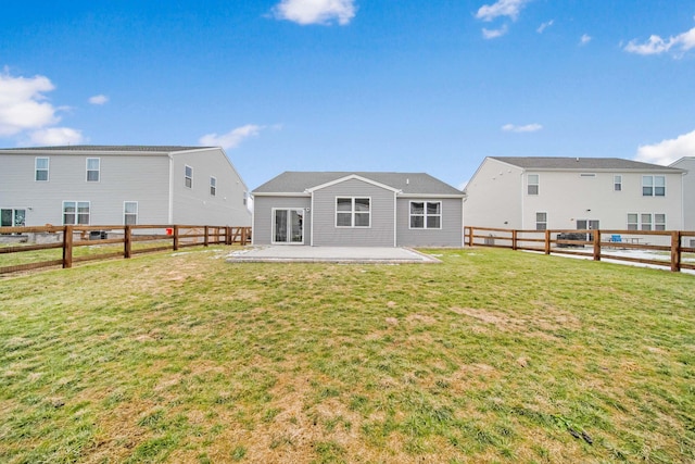 back of house with a fenced backyard, a lawn, and a patio