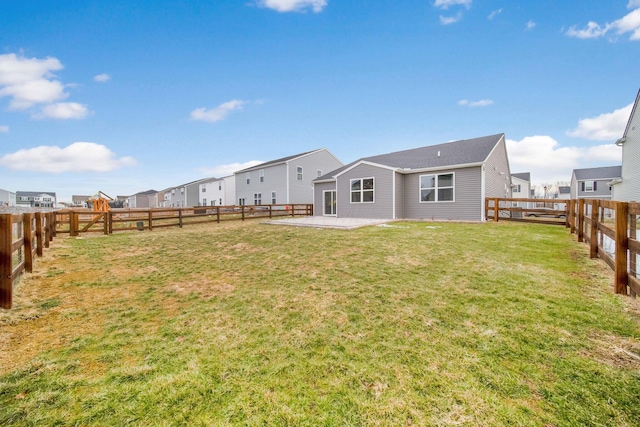 rear view of house featuring a patio, a lawn, a fenced backyard, and a residential view