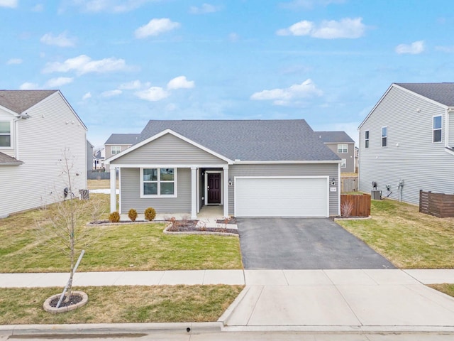 ranch-style home with an attached garage, a shingled roof, aphalt driveway, and a front yard